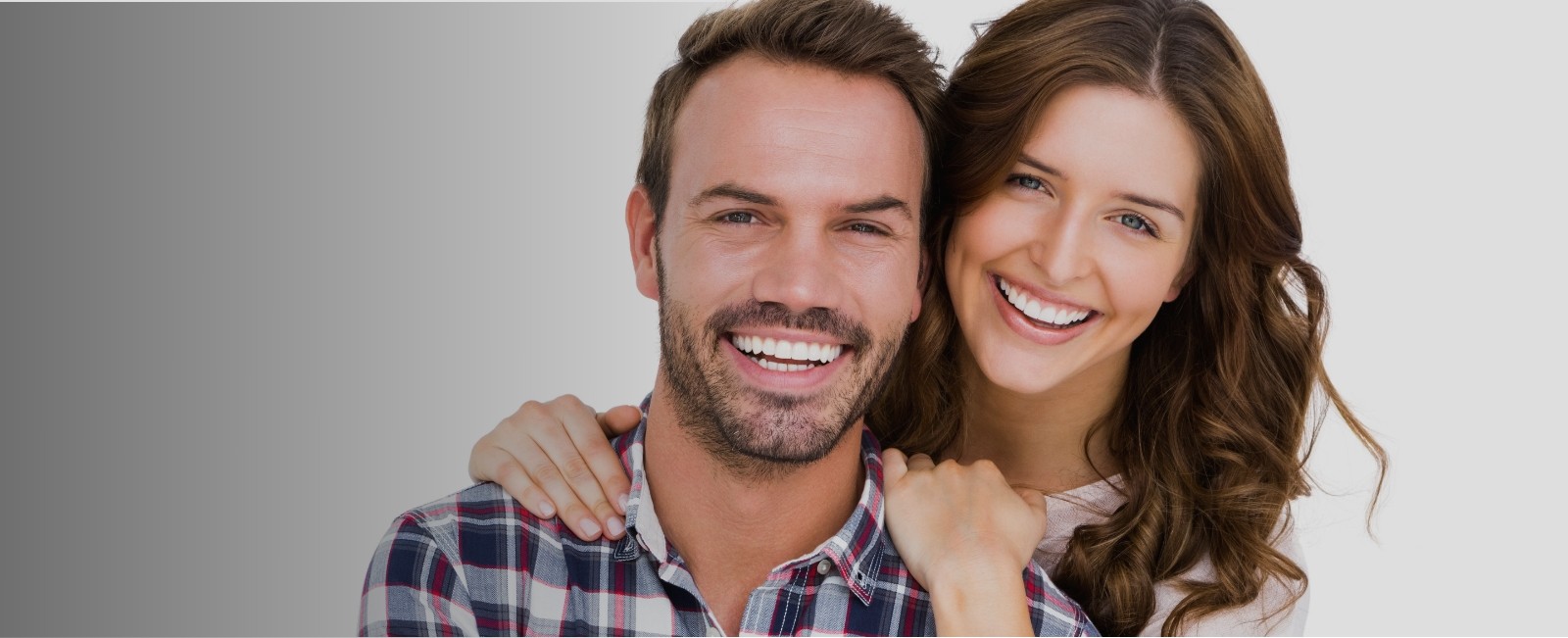 Man and woman smiling after visiting their dentist