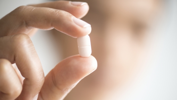 Close up of hand holding white pill